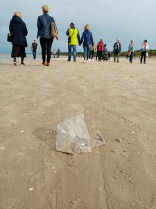 plastic bag on a sand, people walking at a back ground